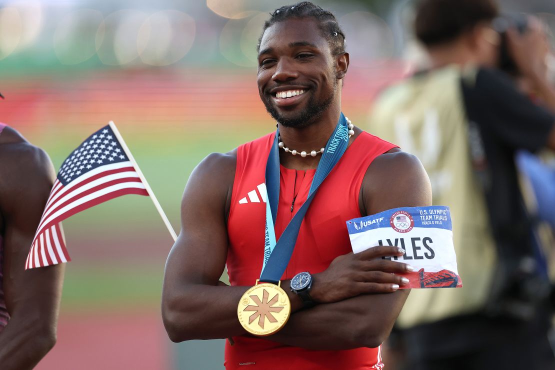 Lyles poses with the flag and his gold medal after the race.