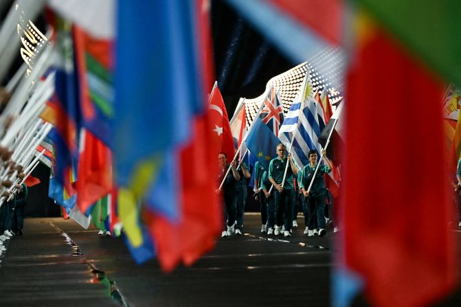 Volunteers carry flags on the Jena Bridge, which crosses the Seine River in Paris, during the opening ceremony.