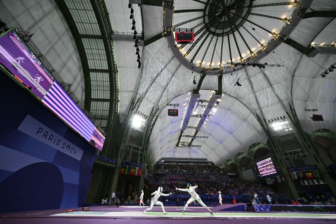 Japanese fencer Miho Yoshimura, left, competes against Rwanda’s Tufaha Uwihoreye in an épée round-of-64 bout on July 27.