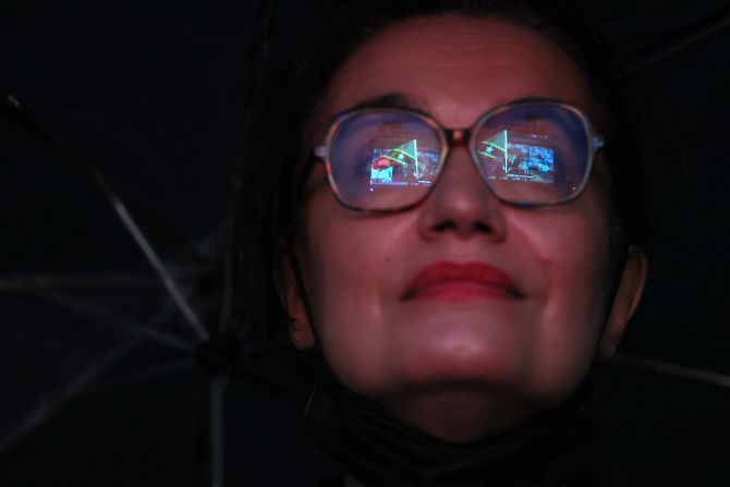 The flag of St. Kitts and Nevis is reflected in the glasses of a spectator during the opening ceremony.