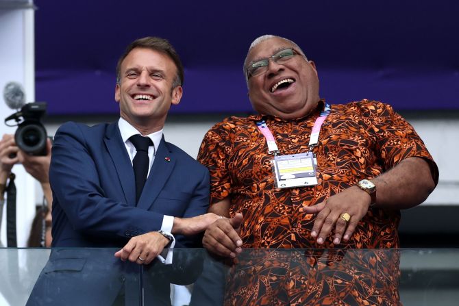 French President Emmanuel Macron, left, watches the gold-medal rugby match with Fiji President Wiliame Katonivere.