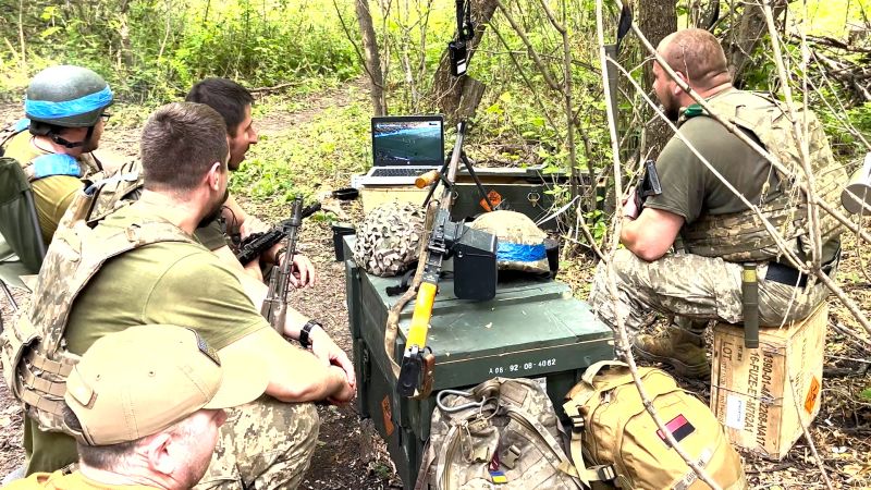 Ukrainian soldiers cheer on national soccer team from the frontline