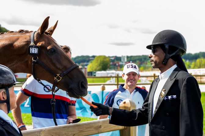 Rapper Snoop Dogg feeds a horse at the dressage event on August 3.