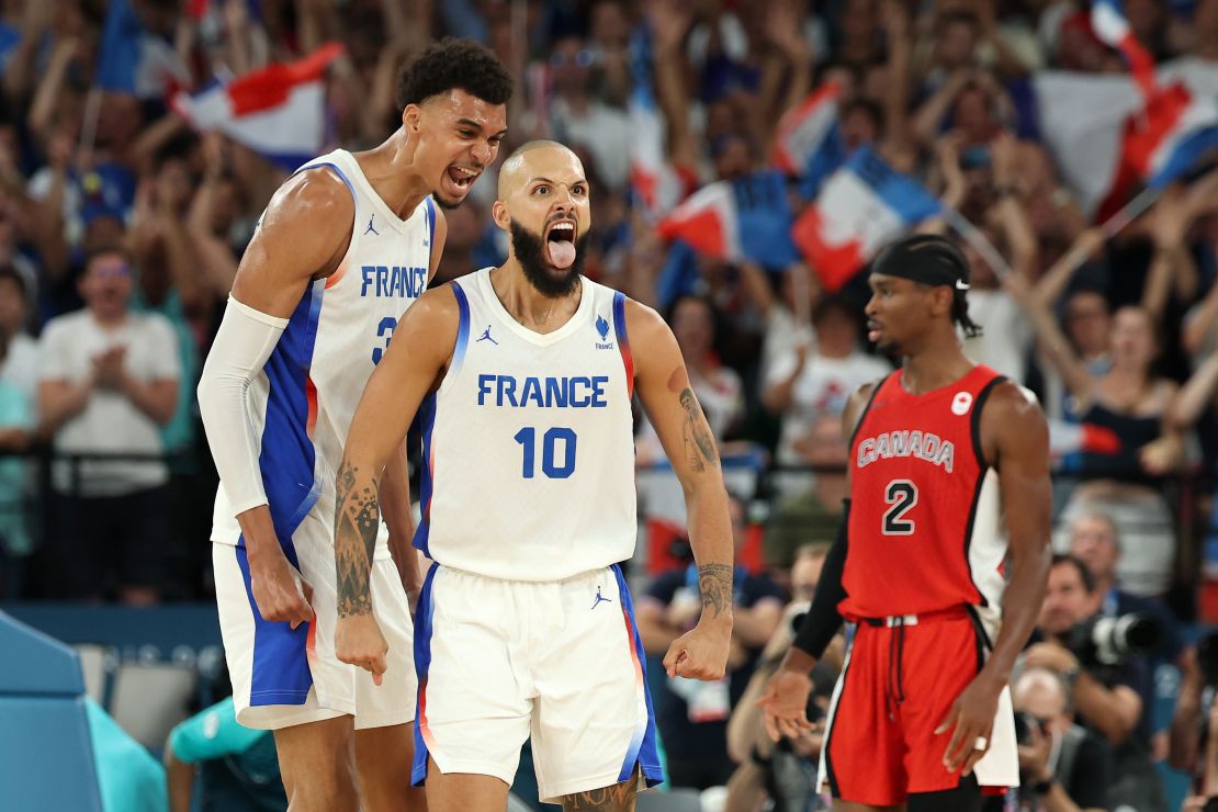 Victor Wembanyama, left, and Evan Fournier of France celebrate while Shai Gilgeous-Alexander of Canada looks on during their game on Tuesday.