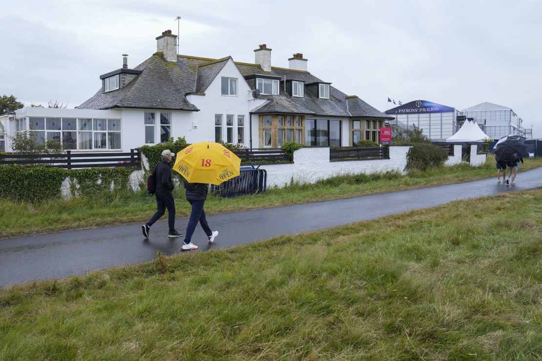 Spectators walk past Blackrock House and its "for sale" sign.