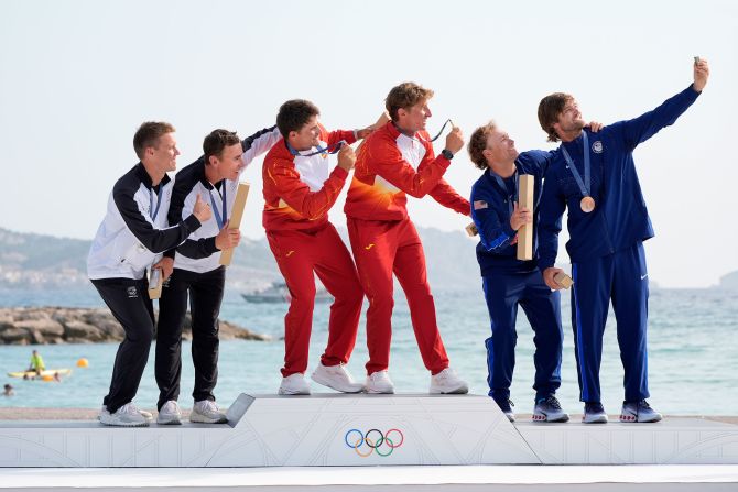 From left, Isaac McHardie and William McKenzie of New Zealand, Diego Botin Le Chever and Florian Trittel Paul of Spain, and Ian Barrows and Hans Henken of the United States, take a group selfie during the men's skiff medal ceremony on August 2.