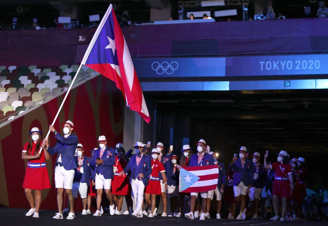 Flag bearers Adriana Díaz and Brian Afanador of Team Puerto Rico walk their team out during the opening ceremony at the Tokyo 2020 Olympic Games.