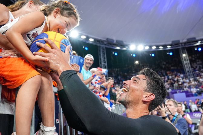 A fan receives a signed ball from Arvin Slagter of the Netherlands after <a href="https://www.cnn.com/sport/live-news/paris-olympics-news-2024-08-05#h_68a38270e283373a1ceb4610dd2412ca">his 3x3 basketball team won gold</a> on August 5.