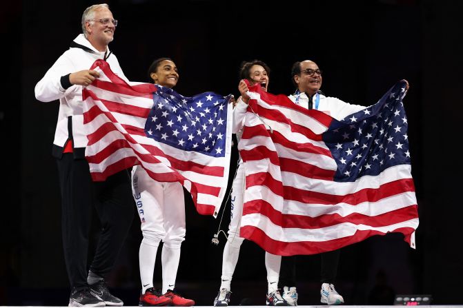 US fencers Lauren Scruggs, center left, and Lee Kiefer celebrate after facing off in the foil final on July 28. <a href="https://www.cnn.com/sport/live-news/paris-olympics-news-2024-07-28#h_a5ef3047654247f764f7f57ca714fe53">Kiefer overwhelmed Scruggs 15-6</a> to win the event for the second straight Olympics.