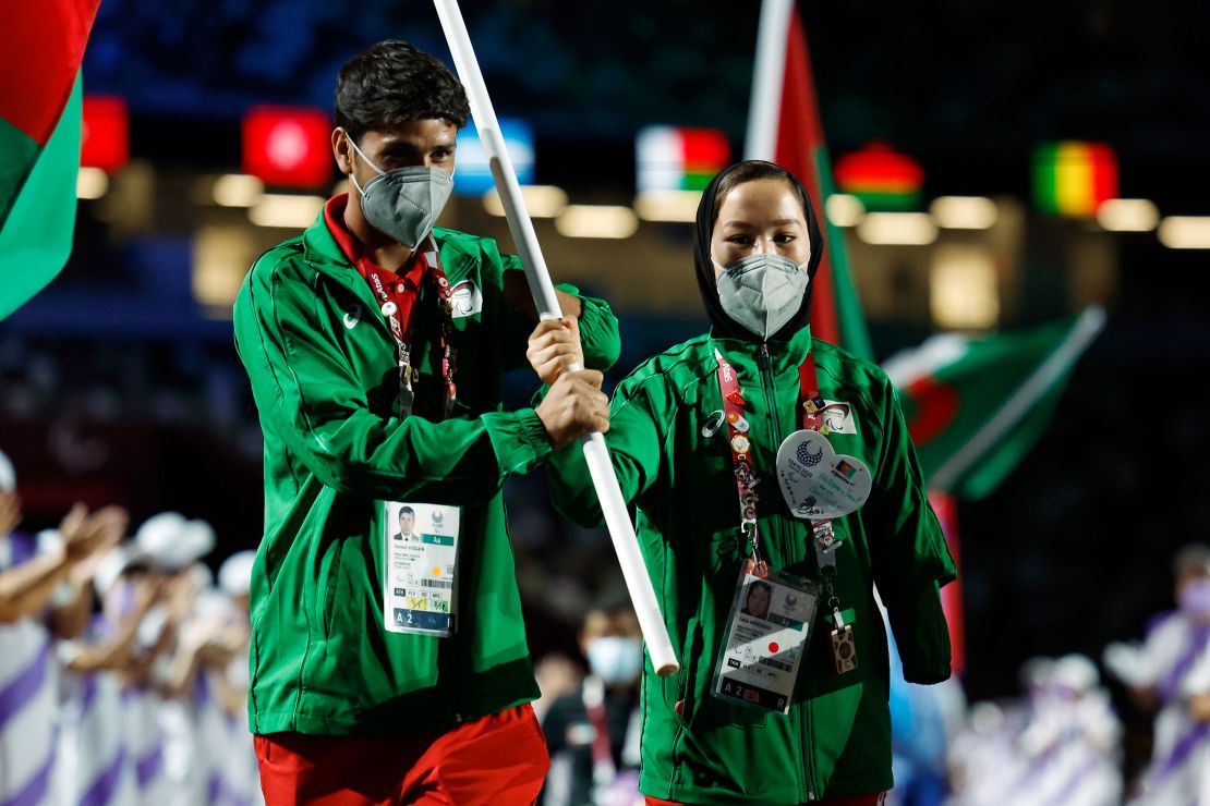 Hossain Rasouli (left) and Zakia Khudadadi carry Afghanistan's flag at the closing ceremony of the Tokyo Paralympics.