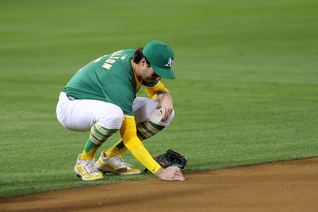 Oakland A's Jacob Wilson collects dirt from the field after the final game at the Oakland Coliseum