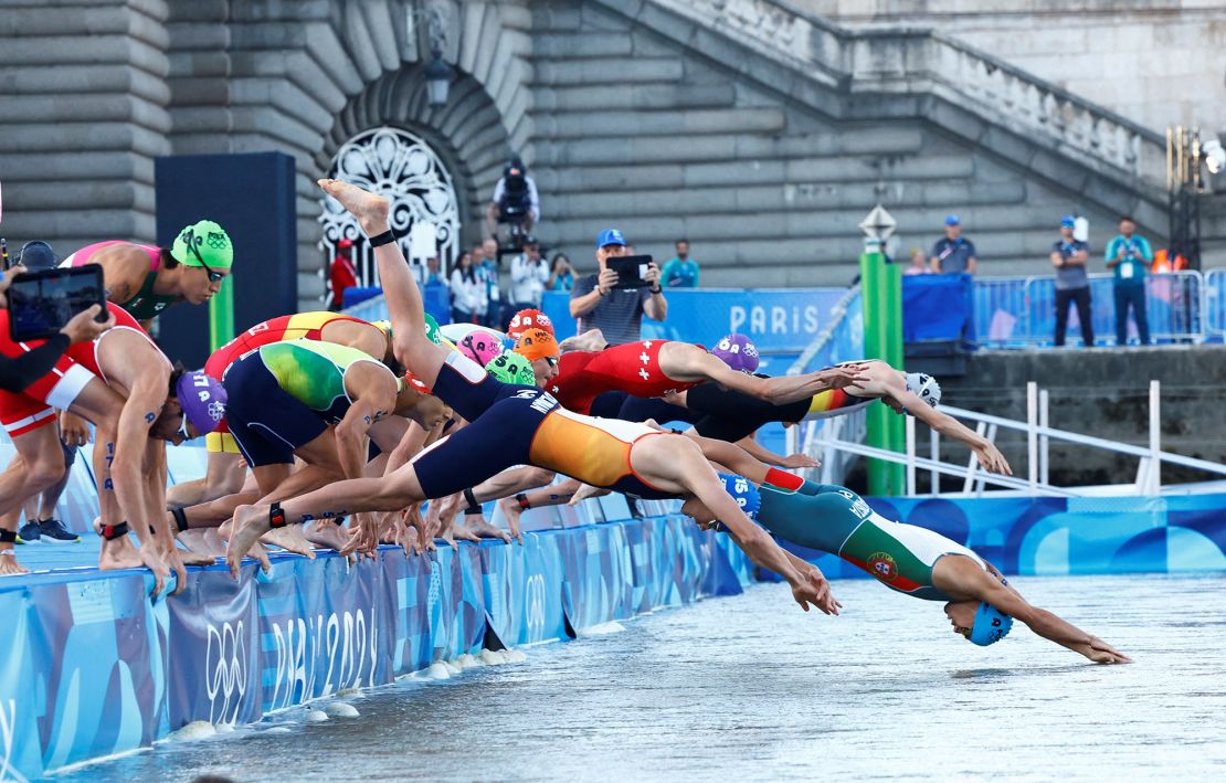 Triathletes dive into the River Seine during the mixed relay race.