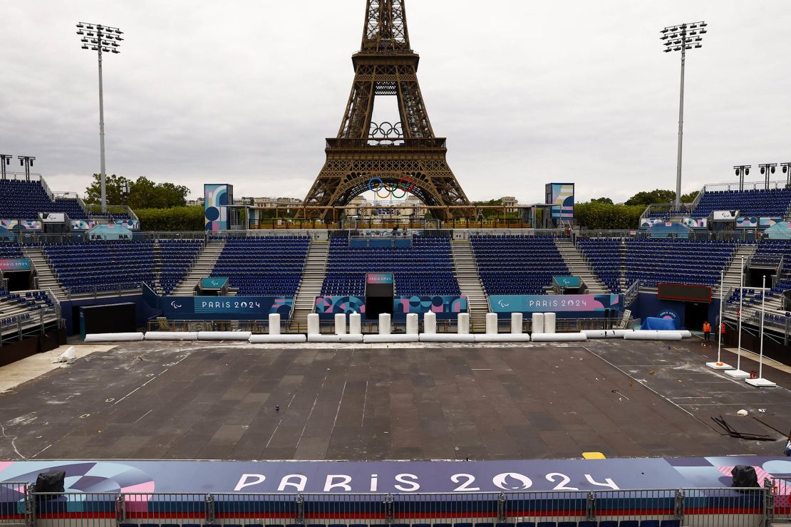 Workers convert the Eiffel Tower Stadium from the beach volleyball venue at the Olympic Games to the blind football venue for the coming Paralympic Games.