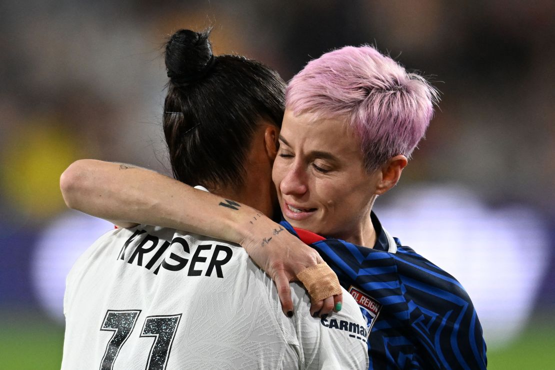 TOPSHOT - Gotham FC's US defender #11 Ali Krieger hugs OL Reign's US midfielder #15 Megan Rapinoe as she is helped off the pitch after an injury in the early minutes of the first half of the National Women's Soccer League final match between OL Reign and Gotham FC at Snapdragon Stadium in San Diego, California, on November 11, 2023. US women's football icon Megan Rapinoe limped out of the final game of her storied career, suffering an apparent ankle injury less than three minutes into the National Women's Soccer League Final. (Photo by Robyn Beck / AFP) (Photo by ROBYN BECK/AFP via Getty Images)