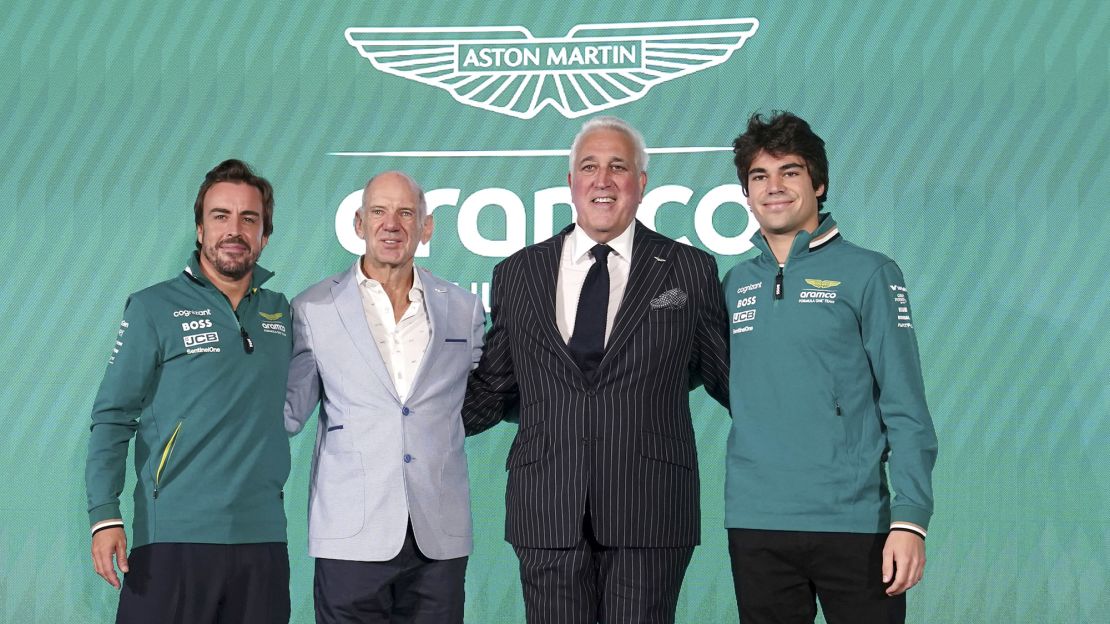 Aston Martin drivers Fernando Alonso (left) and Lance Stroll (right) with Adrian Newey (center left), newly appointed managing technical partner, and Lawrence Stroll, executive chairman.