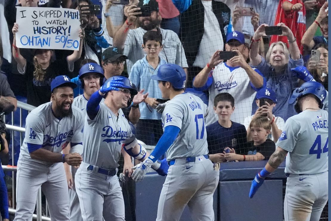 Los Angeles Dodgers' Shohei Ohtani (17) is congratulated by teammates after he hit a home run scoring Andy Pages, during the seventh inning of a baseball game against the Miami Marlins, Thursday, Sept. 19, 2024, in Miami. (AP Photo/Wilfredo Lee)