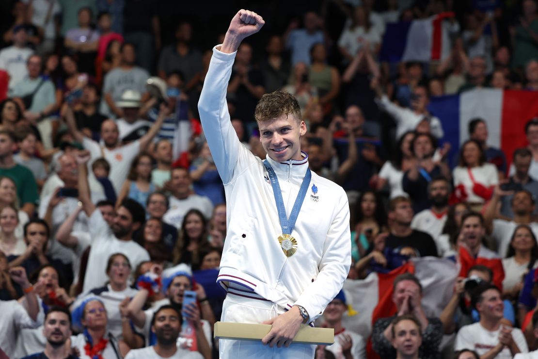 NANTERRE, FRANCE - JULY 31: Gold Medalist Leon Marchand of Team France celebrates on the podium during the Swimming medal ceremony after the Men's 200m Breaststroke Final on day five of the Olympic Games Paris 2024 at Paris La Defense Arena on July 31, 2024 in Nanterre, France. (Photo by Quinn Rooney/Getty Images)