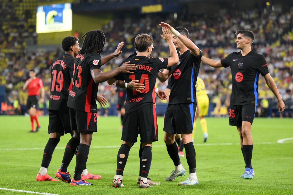 Torre celebrates with his teammates after scoring.