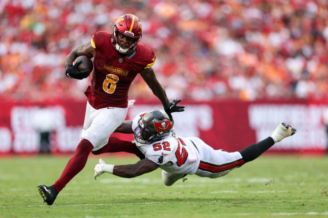 Washington Commanders running back Brian Robinson Jr. breaks a tackle from Tampa Bay Buccaneers linebacker K.J. Britt in Tampa, Florida, on September 8. The Buccaneers beat the Commanders 37-20.