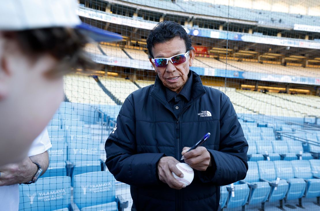 Former pitcher Fernando Valenzuela of the Los Angeles Dodgers gives autographs to fans before the game against the San Francisco Giants at Dodger Stadium on April 1 in Los Angeles.