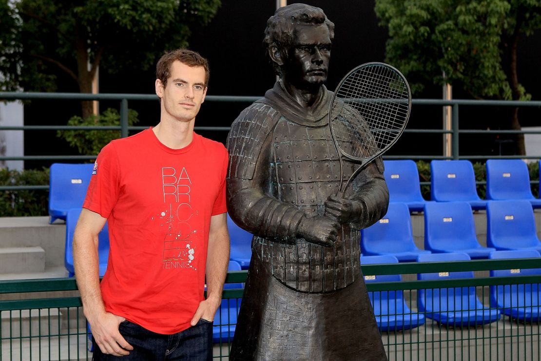 Andy Murray poses alongside his terracotta sculpture.