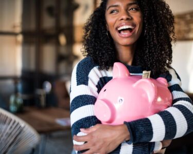 A person hugging a piggy bank.