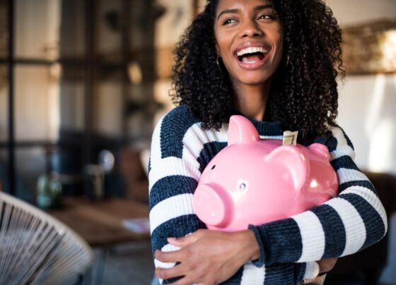 A person hugging a piggy bank.