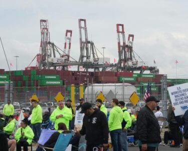 An International Longshoremen's Association (ILA) member holds an American Flag on the picket line on Tuesday, Oct. 1, 2024 as the ILA went on strike at the Georgia Ports Authority in Garden City, Ga.