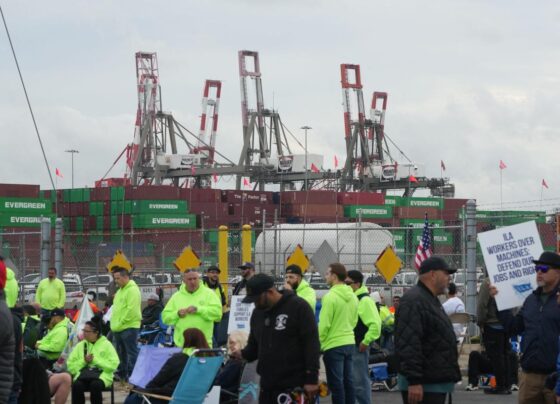 An International Longshoremen's Association (ILA) member holds an American Flag on the picket line on Tuesday, Oct. 1, 2024 as the ILA went on strike at the Georgia Ports Authority in Garden City, Ga.