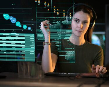 A person looking at graphs and data on a see-though computer display.