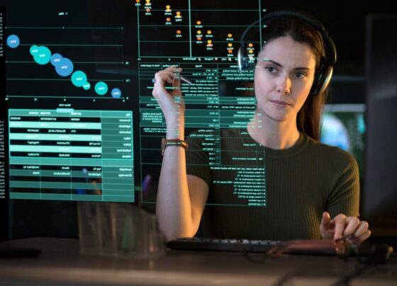 A person looking at graphs and data on a see-though computer display.