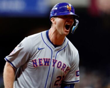 Mets players celebrate with Alonso (left) after his home run.