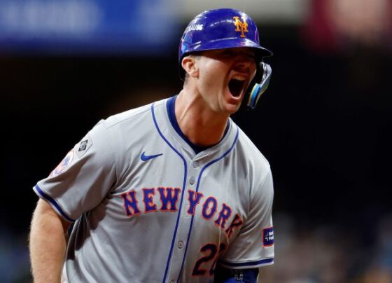 Mets players celebrate with Alonso (left) after his home run.