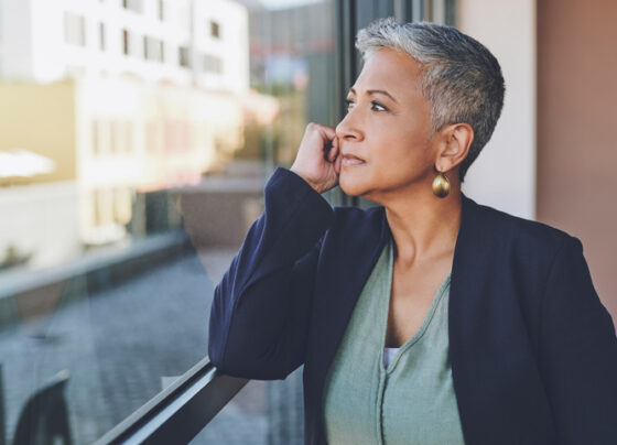 A woman looks out of the window in her office and contemplates whether she can afford to retire at 66.