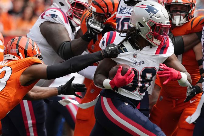 Rhamondre Stevenson of the New England Patriots runs the ball against Cincinnati Bengals defenders in Cincinnati on September 8. The Patriots beat the Bengals 16-10.