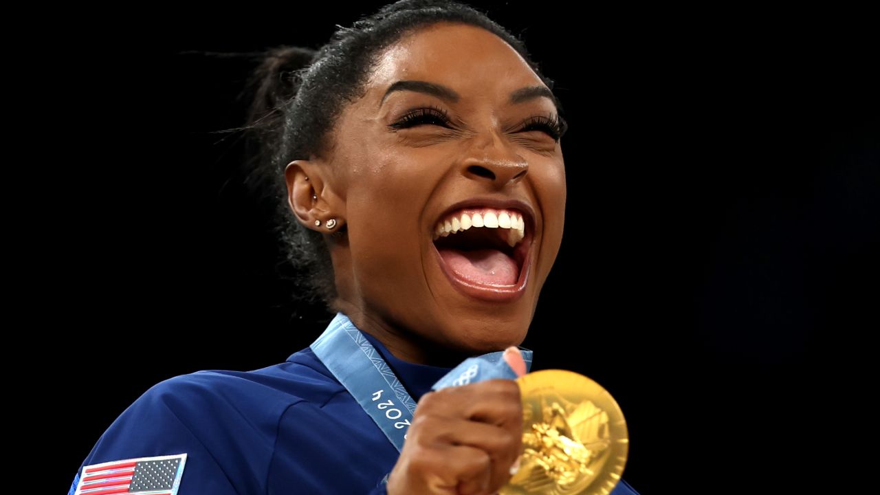 PARIS, FRANCE - JULY 30: Gold medalist Simone Biles of Team United States reacts on the podium during the medal ceremony for the Artistic Gymnastics Women's Team Final on day four of the Olympic Games Paris 2024 at Bercy Arena on July 30, 2024 in Paris, France. (Photo by Naomi Baker/Getty Images)