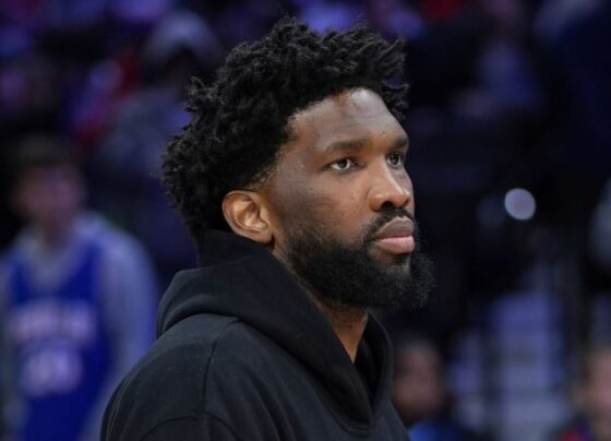 Philadelphia 76ers' Joel Embiid, top left, watches from the bench during the 76ers' game. Embiid missed the game to manage an injured left knee.