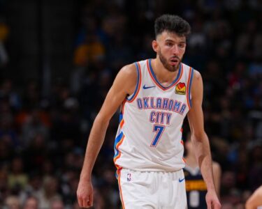 Warriors' Andrew Wiggins collides with OKC's Chet Holmgren on Sunday.