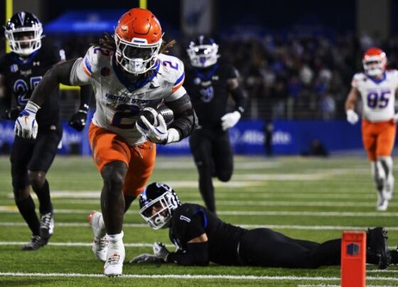 Ashton Jeanty high fives fans after Boise State's win.