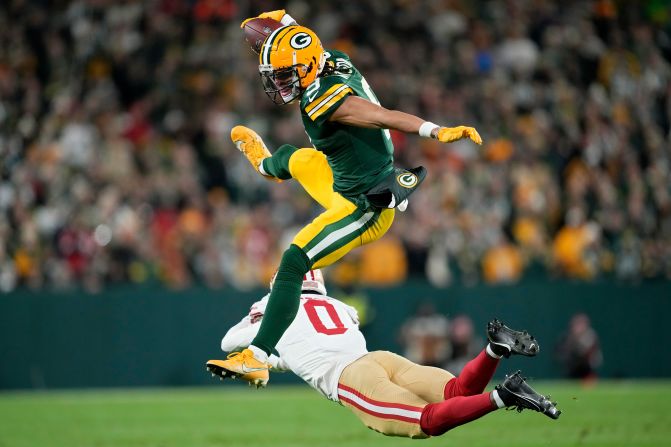 Green Bay Packers wide receiver Christian Watson leaps over San Francisco 49ers cornerback Renardo Green at Lambeau Field in Green Bay, Wisconsin, on Sunday, November 24. The Packers won 38-10.