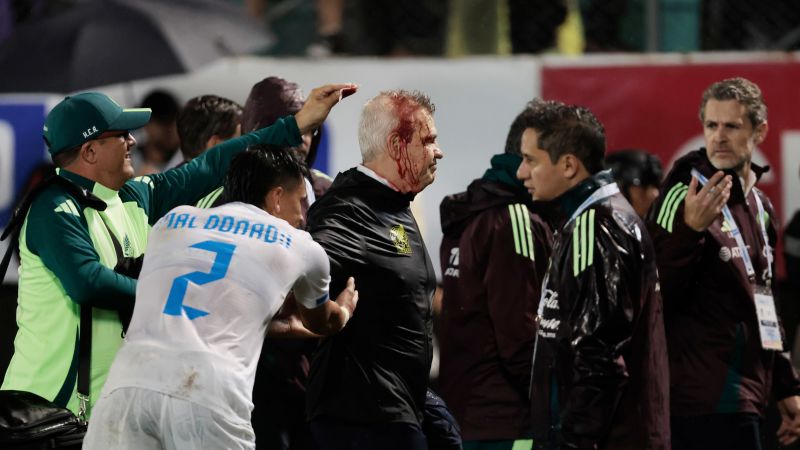 Mexico soccer manager Javier Aguirre struck by can thrown onto the pitch from stands, left with bloodied head | CNN