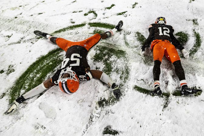 Cleveland Browns defensive end Ogbo Okoronkwo and safety Rodney McLeod Jr. make snow angels after beating the Pittsburgh Steelers 24-19 in Cleveland on Thursday, November 21.