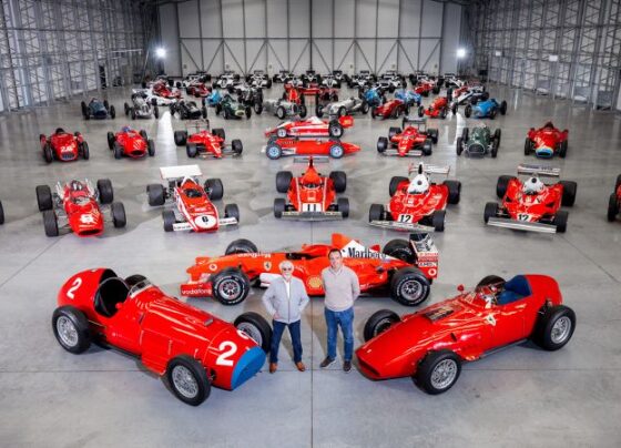 Bernie Ecclestone and Tom Hartley Jr. stand with Ecclestone's car collection.