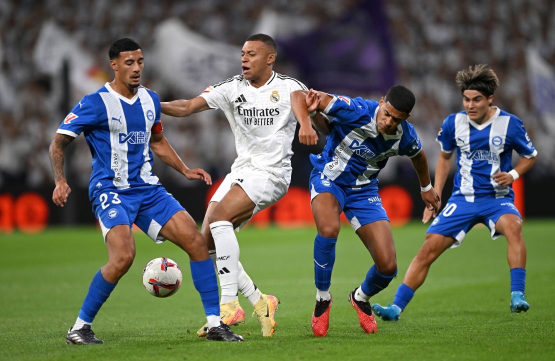 Mbappé is challenged by Carlos Benavidez and Santiago Mourino of Deportivo Alavés on September 24 in Madrid.