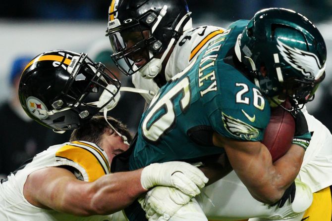 Pittsburgh Steelers defensive tackle Dean Lowry loses his helmet as he takes down Philadelphia Eagles running back Saquon Barkley in Philadelphia on December 15. The Eagles won 27-13