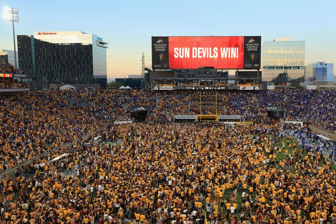 Fans rush the field before a resumption of play with 1 second left on the clock during the game between the Arizona State Sun Devils and the BYU Cougars at Mountain America Stadium on November 23 in Tempe, Arizona.