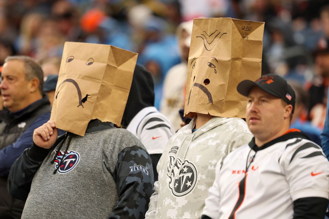 Tennessee Titans fans wear paper bags while watching their team play the Cincinnati Bengals. The Titans have been knocked out of playoff contention.