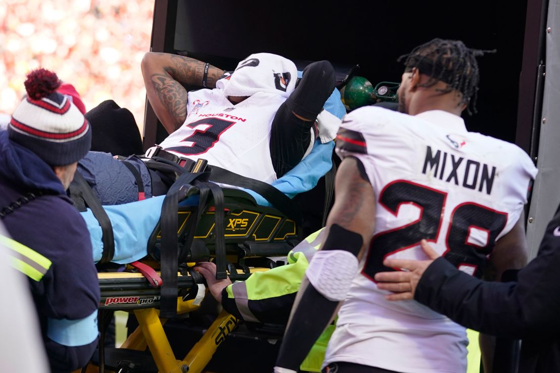 Houston Texans wide receiver Tank Dell covers his face as he is taken off the field on a stretcher after being injured.