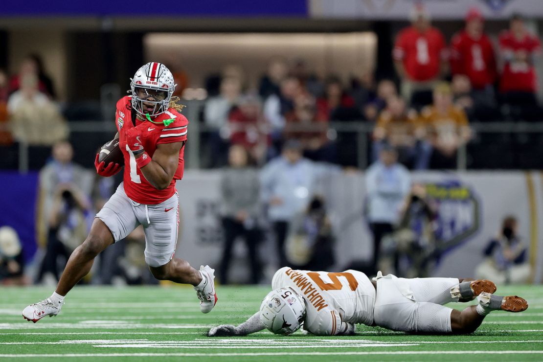 Quinshon Judkins of the Ohio State Buckeyes runs with the ball past Malik Muhammad #5 of the Texas Longhorns in the fourth quarter during the Goodyear Cotton Bowl at AT&T Stadium on January 10.