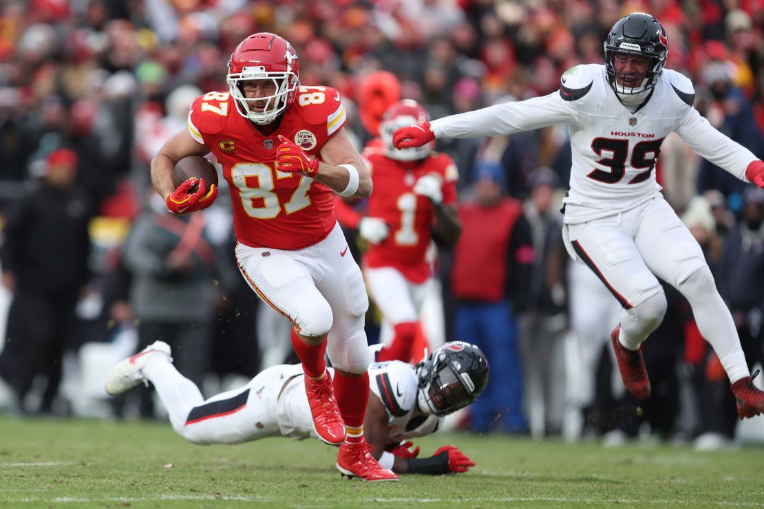 Kansas City Chiefs tight end Travis Kelce (87) runs with the ball as Houston Texans safety Calen Bullock (21) and linebacker Henry To'oTo'o (39) defend during the first half of an NFL football AFC divisional playoff game.